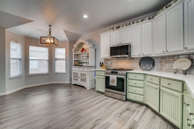 1237 Bay Line Dr, Rockwall, TX 75087 - kitchen with stainless steel appliances, green cabinets, a chandelier, light wood-style floors, and recessed lighting