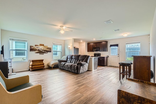9263 Summerlee St, Dallas, TX 75227 - living area featuring light wood finished floors, plenty of natural light, and a ceiling fan
