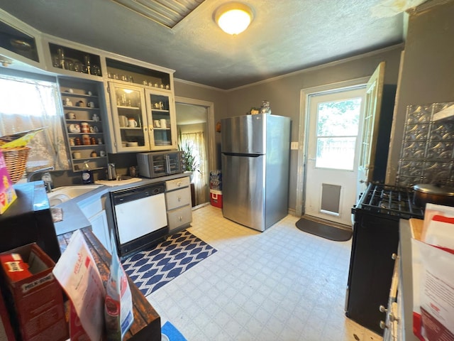 523 Bryson Ave, Athens, TX 75751 - kitchen with freestanding refrigerator, dishwasher, light floors, crown molding, and glass insert cabinets