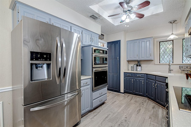 5307 Oak Branch Dr, Arlington, TX 76016 - kitchen with stainless steel appliances, a textured ceiling, blue cabinetry, light wood-style floors, and ceiling fan