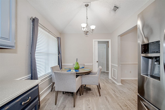 5307 Oak Branch Dr, Arlington, TX 76016 - dining room featuring a chandelier, light wood-style floors, lofted ceiling, and a textured ceiling