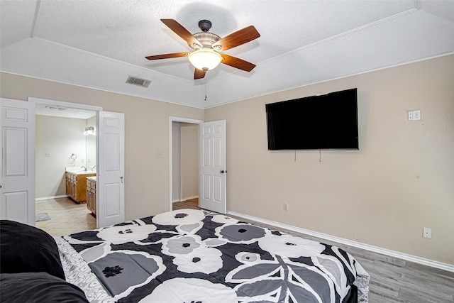 5307 Oak Branch Dr, Arlington, TX 76016 - bedroom featuring a textured ceiling, ensuite bathroom, ceiling fan, and light wood-style flooring