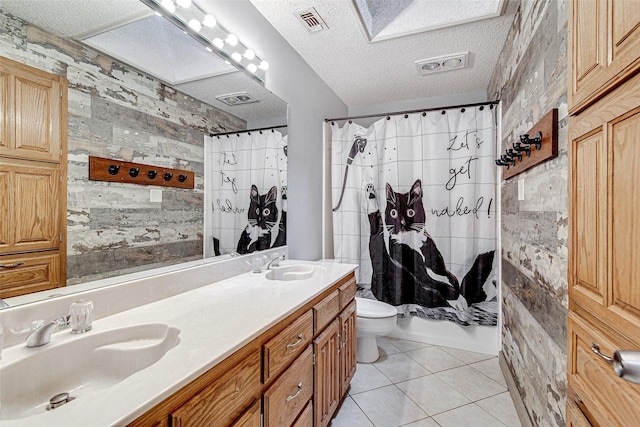 5307 Oak Branch Dr, Arlington, TX 76016 - bathroom with double vanity, tile patterned floors, a textured ceiling, and shower / bath combo with shower curtain