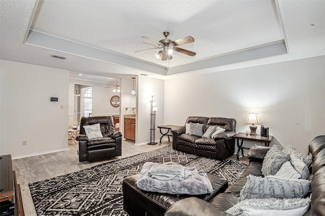 5307 Oak Branch Dr, Arlington, TX 76016 - living room with ceiling fan, light wood-type flooring, a raised ceiling, and a textured ceiling
