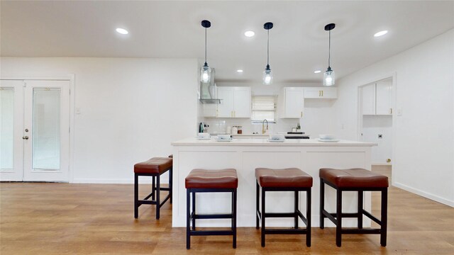 1608 Holt St, Fort Worth, TX 76103 - kitchen with a breakfast bar area, white cabinetry, decorative backsplash, pendant lighting, and recessed lighting