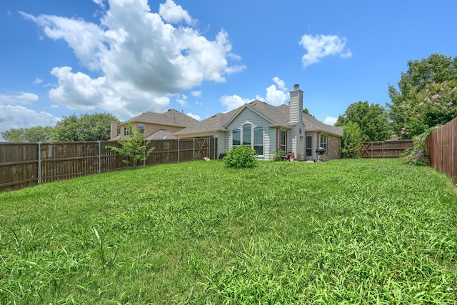 703 Monterey Dr, Rockwall, TX 75087 - rear view of house with a fenced backyard and a chimney