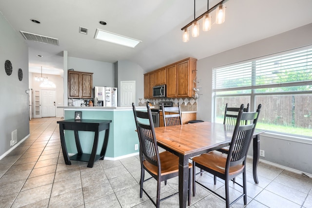 703 Monterey Dr, Rockwall, TX 75087 - dining space featuring light tile patterned floors, plenty of natural light, and vaulted ceiling