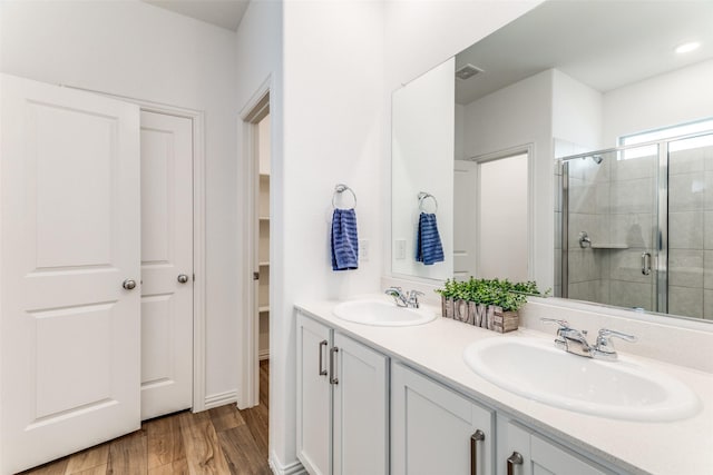 1233 Western Yarrow Ave, Justin, TX 76247 - bathroom featuring a shower stall, double vanity, wood finished floors, and a walk in closet