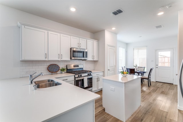 1233 Western Yarrow Ave, Justin, TX 76247 - kitchen with stainless steel appliances, backsplash, a center island, light countertops, and white cabinets