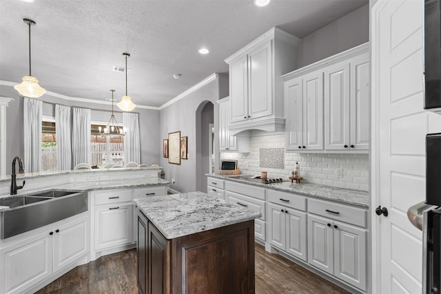 6202 Carrizo Dr, De Cordova, TX 76049 - kitchen featuring arched walkways, white cabinetry, dark wood-style flooring, black electric stovetop, and crown molding