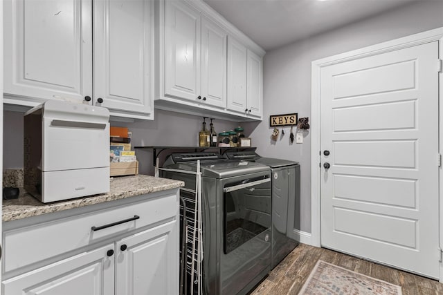 6202 Carrizo Dr, De Cordova, TX 76049 - laundry area featuring washing machine and clothes dryer, cabinet space, and wood finished floors