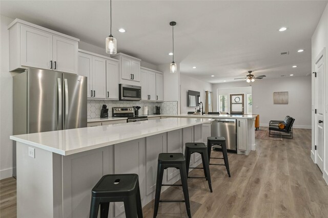 532 W Florence St, Denison, TX 75020 - kitchen with stainless steel appliances, a peninsula, backsplash, recessed lighting, and a center island