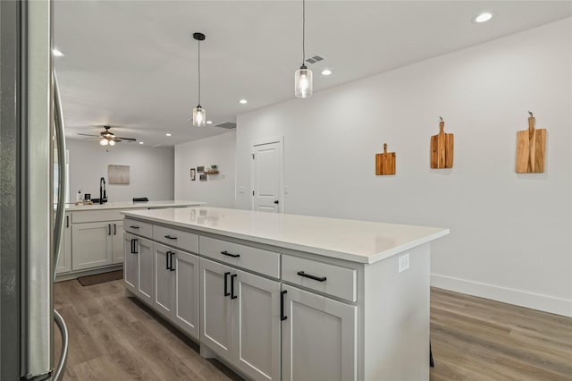 532 W Florence St, Denison, TX 75020 - kitchen with freestanding refrigerator, a center island, wood finished floors, recessed lighting, and light countertops
