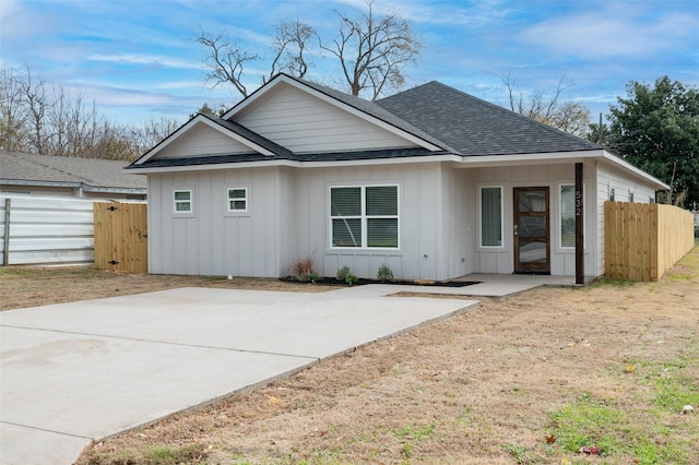 532 W Florence St, Denison, TX 75020 - back of property with board and batten siding, a shingled roof, and a patio