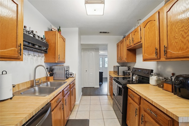4328 Coryell Way, Mesquite, TX 75150 - kitchen with black / electric stove, dishwasher, light tile patterned floors, brown cabinets, and wood counters