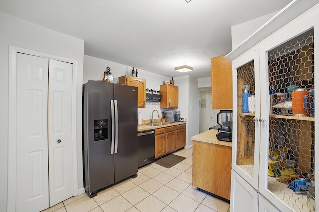 4328 Coryell Way, Mesquite, TX 75150 - kitchen featuring stainless steel fridge with ice dispenser, dishwasher, light countertops, light tile patterned floors, and brown cabinetry