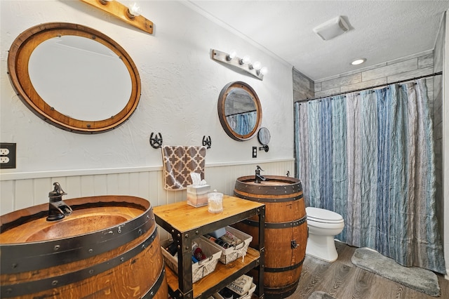 4328 Coryell Way, Mesquite, TX 75150 - full bathroom featuring wood finished floors, wainscoting, a shower with shower curtain, vanity, and a textured ceiling