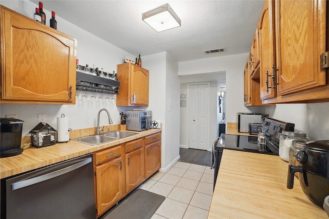 4328 Coryell Way, Mesquite, TX 75150 - kitchen featuring stainless steel dishwasher, black range with electric stovetop, light tile patterned floors, butcher block countertops, and brown cabinets
