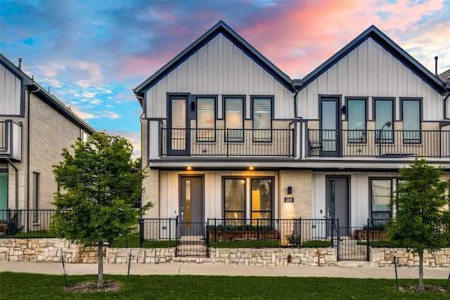 2238 Rook Dr, Dallas, TX 75211 - view of front facade featuring a balcony, board and batten siding, a fenced front yard, and a porch