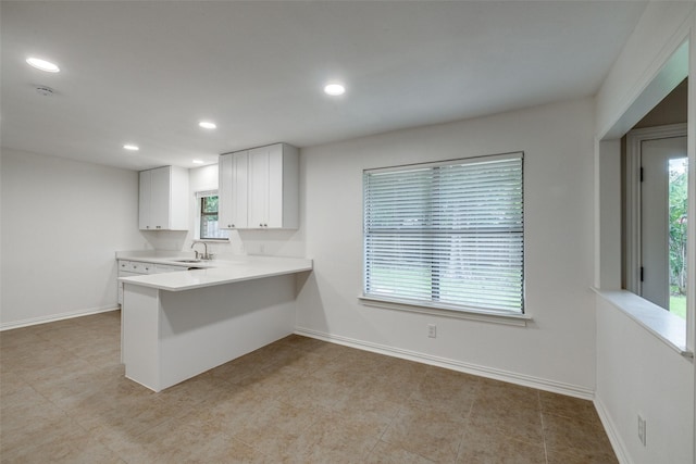 5125 Yucca Ct, Arlington, TX 76017 - kitchen featuring light countertops, a peninsula, white cabinetry, recessed lighting, and a breakfast bar