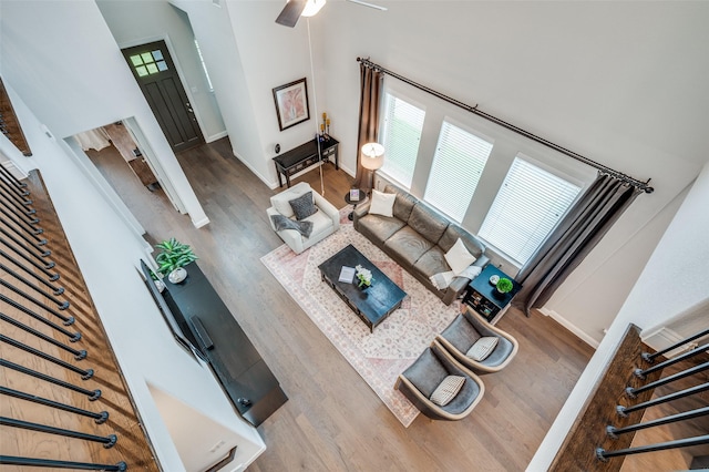 3418 River Trl, Frisco, TX 75034 - living room featuring wood finished floors, stairs, a high ceiling, and a ceiling fan
