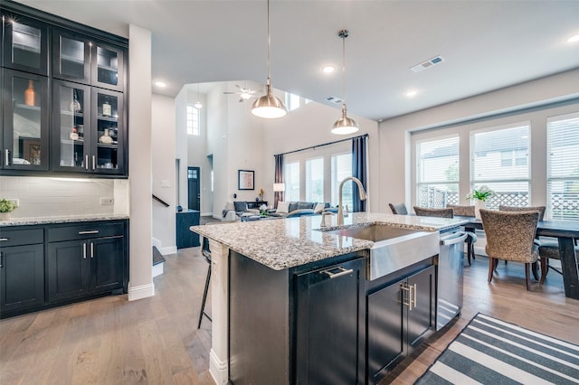 3418 River Trl, Frisco, TX 75034 - kitchen featuring dishwasher, light wood-style floors, decorative backsplash, healthy amount of natural light, and recessed lighting