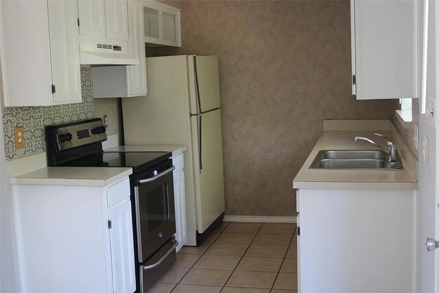 627 Cherry Ln, Southlake, TX 76092 - kitchen with stainless steel range with electric cooktop, under cabinet range hood, white cabinetry, tasteful backsplash, and light countertops