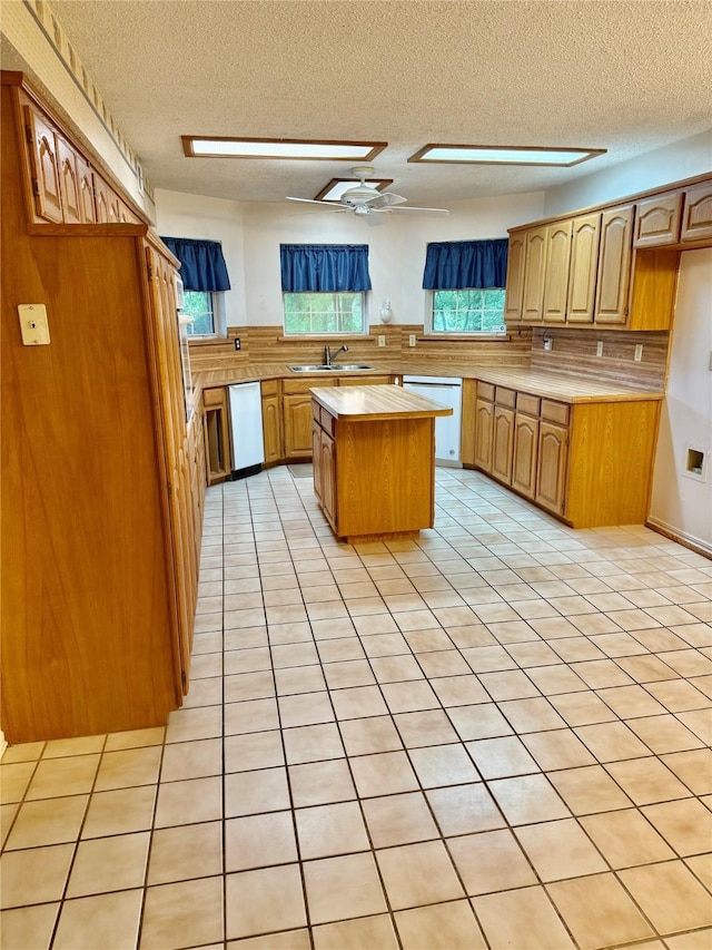 2909 Troy Rd, Wylie, TX 75098 - kitchen featuring dishwasher, light countertops, a textured ceiling, a kitchen island, and light tile patterned flooring