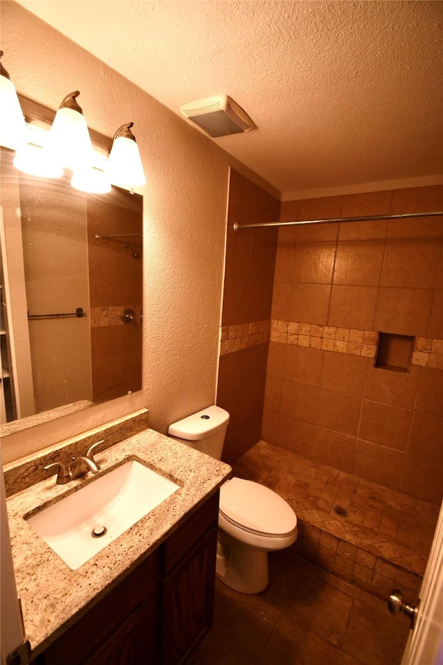 2625 Fairbrook St, Irving, TX 75062 - bathroom featuring a textured wall, a textured ceiling, tiled shower, and vanity