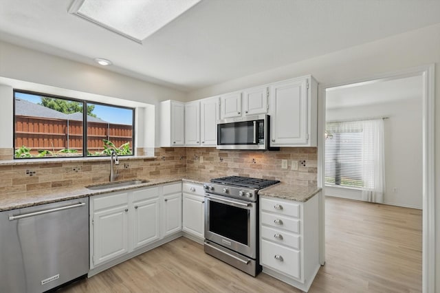 1800 Chatham Dr, Flower Mound, TX 75028 - kitchen with appliances with stainless steel finishes, light stone countertops, light wood-style floors, and backsplash