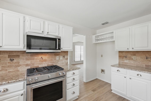 1800 Chatham Dr, Flower Mound, TX 75028 - kitchen with stainless steel appliances, light stone countertops, and white cabinetry