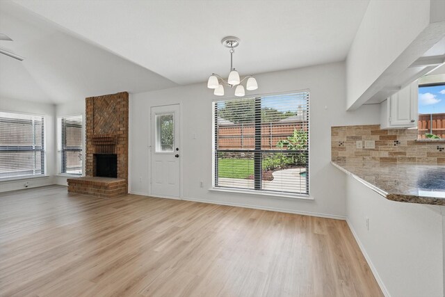 1800 Chatham Dr, Flower Mound, TX 75028 - unfurnished dining area with a chandelier, light wood-style floors, and a brick fireplace
