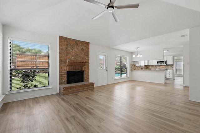 1800 Chatham Dr, Flower Mound, TX 75028 - unfurnished living room featuring light wood-type flooring, healthy amount of natural light, a chandelier, a fireplace, and vaulted ceiling