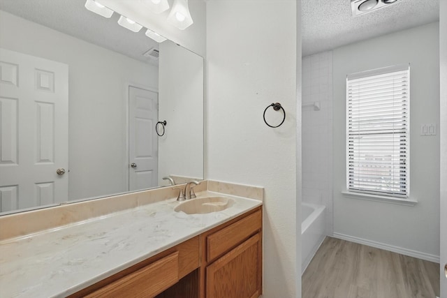 1800 Chatham Dr, Flower Mound, TX 75028 - bathroom with vanity, wood finished floors, a textured ceiling, and  shower combination