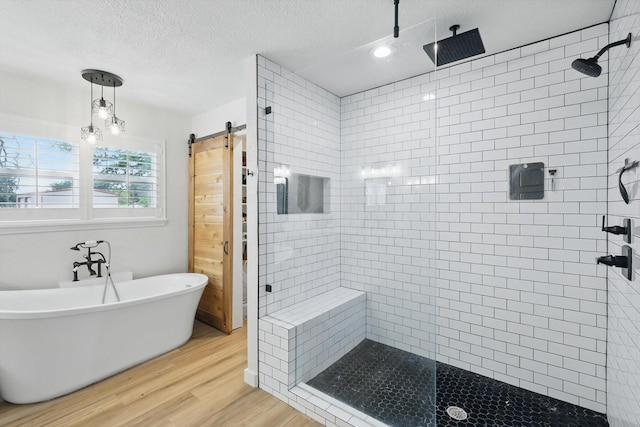 600 Reese Ln, Azle, TX 76020 - bathroom featuring a shower stall, wood finished floors, a freestanding tub, and a textured ceiling