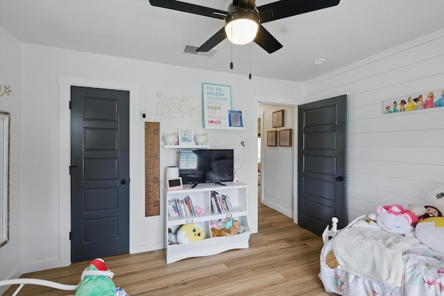 600 Reese Ln, Azle, TX 76020 - bedroom with light wood-style flooring, ceiling fan, and wood walls