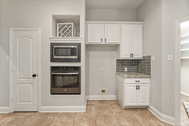 2600 Shiloh Rd, Denton, TX 76210 - kitchen with stainless steel appliances, white cabinetry, tasteful backsplash, and light stone counters