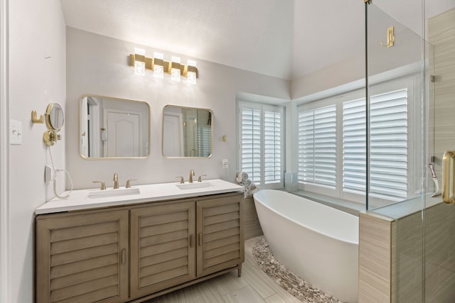 2600 Shiloh Rd, Denton, TX 76210 - bathroom with a freestanding bath, double vanity, a shower stall, lofted ceiling, and tile patterned flooring