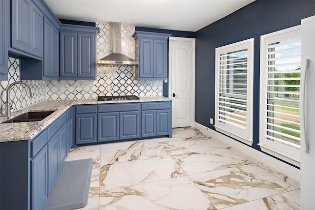 5302 Westfield Dr, Parker, TX 75002 - kitchen with wall chimney range hood, blue cabinetry, stainless steel gas stovetop, decorative backsplash, and light stone counters