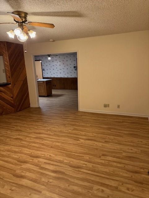 2329 Diana Dr, Sherman, TX 75092 - unfurnished living room with light wood-style flooring, ceiling fan, and a textured ceiling