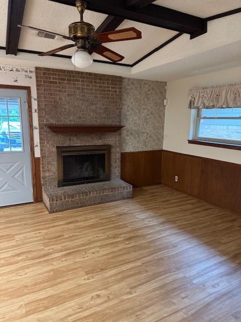 2329 Diana Dr, Sherman, TX 75092 - unfurnished living room with a wainscoted wall, healthy amount of natural light, wood finished floors, a ceiling fan, and a brick fireplace