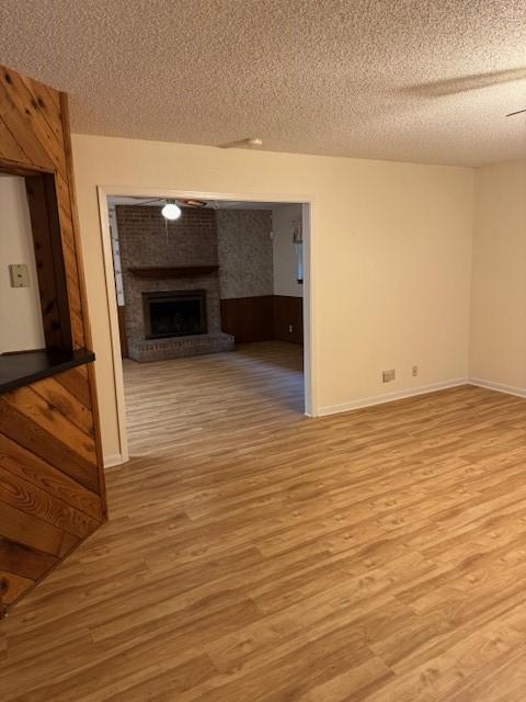 2329 Diana Dr, Sherman, TX 75092 - unfurnished living room with a textured ceiling, wood finished floors, and a fireplace