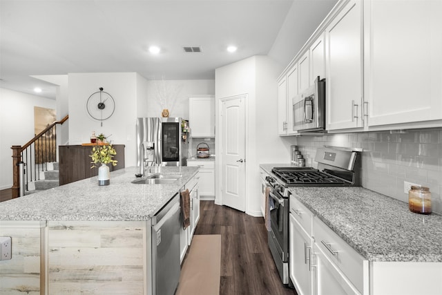 9200 S Field Ln, Arlington, TX 76002 - kitchen featuring appliances with stainless steel finishes, dark wood-type flooring, recessed lighting, decorative backsplash, and an island with sink