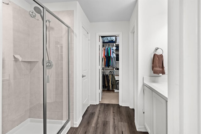 9200 S Field Ln, Arlington, TX 76002 - bathroom featuring a stall shower, wood finished floors, a spacious closet, and vanity