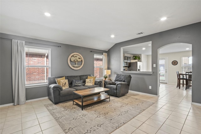 2300 Torch Lake Dr, Forney, TX 75126 - living room featuring arched walkways, light tile patterned floors, recessed lighting, healthy amount of natural light, and lofted ceiling