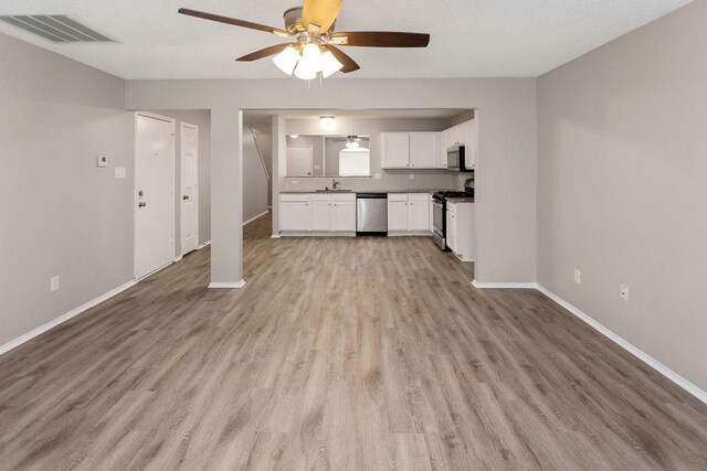 1449 Saint Gallen Ln, Lewisville, TX 75067 - unfurnished living room with ceiling fan and light wood-type flooring