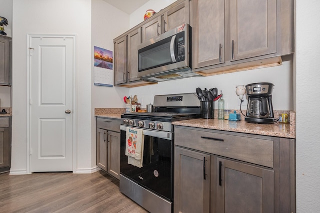 1112 Quaint Mdw, Princeton, TX 75407 - kitchen with appliances with stainless steel finishes, dark wood-style flooring, and light stone countertops