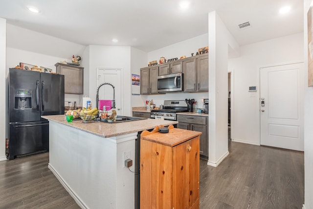 1112 Quaint Mdw, Princeton, TX 75407 - kitchen featuring stainless steel appliances, dark wood-type flooring, a center island with sink, recessed lighting, and dark brown cabinets