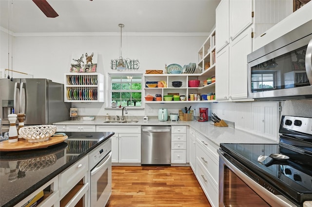 2116 Darby Dan Ct, Granbury, TX 76049 - kitchen with stainless steel appliances, crown molding, healthy amount of natural light, white cabinetry, and light wood-style flooring