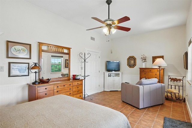 2116 Darby Dan Ct, Granbury, TX 76049 - bedroom with light tile patterned floors, lofted ceiling, wainscoting, and a ceiling fan